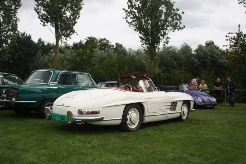 two white vintage cars parked next to each other