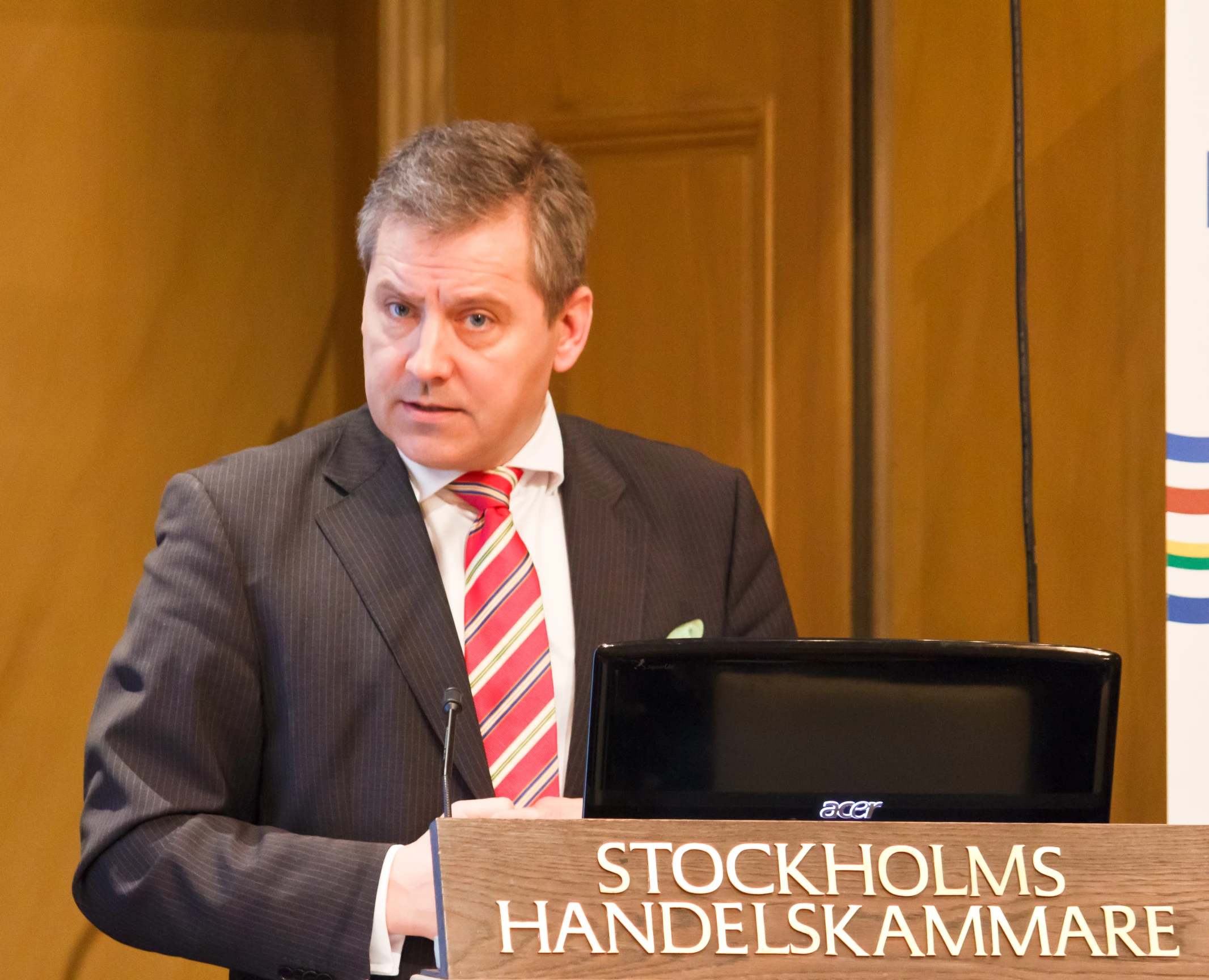 a man speaking in front of two podiums with a microphone