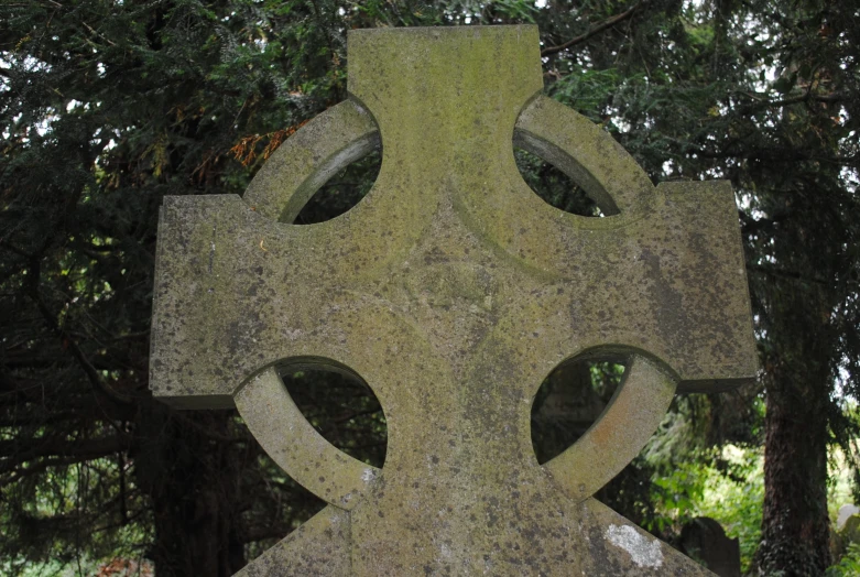 a large white cross is in a park