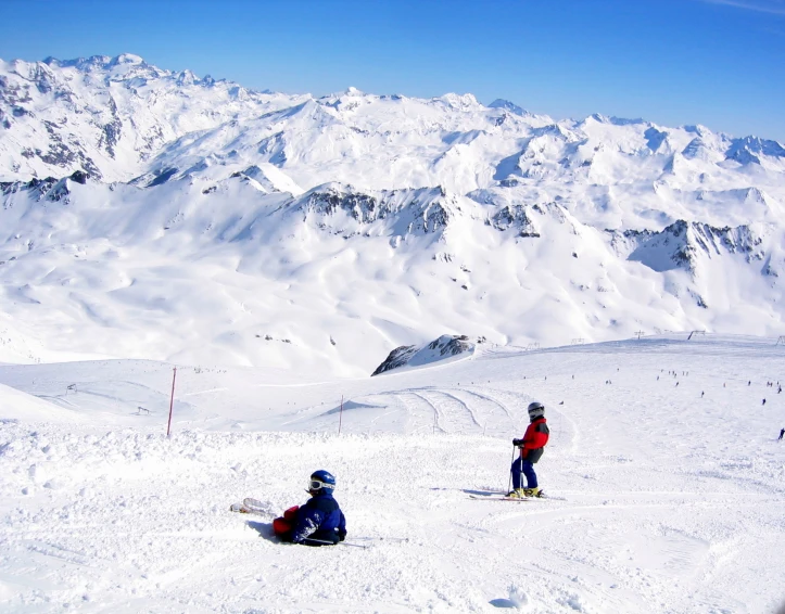 two snowboarders on the mountain slope in the sun