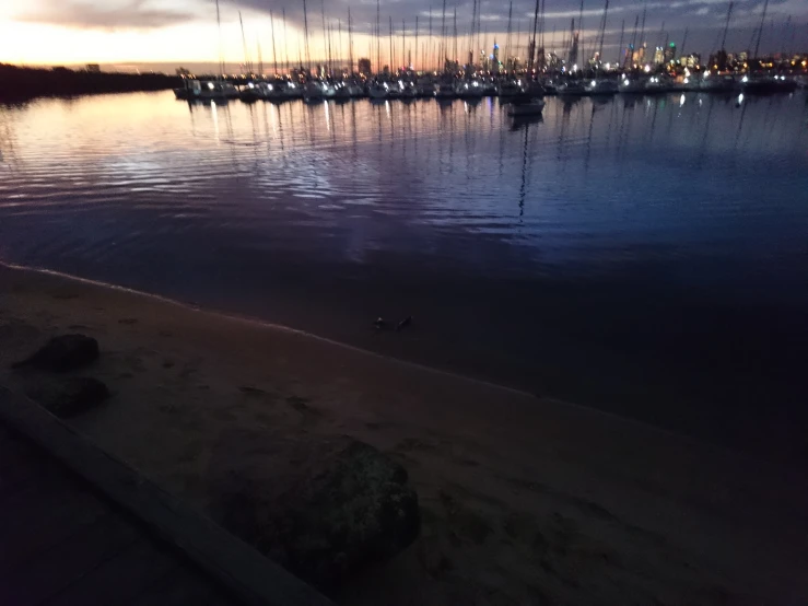 a marina full of ships and yachts under a twilight sky