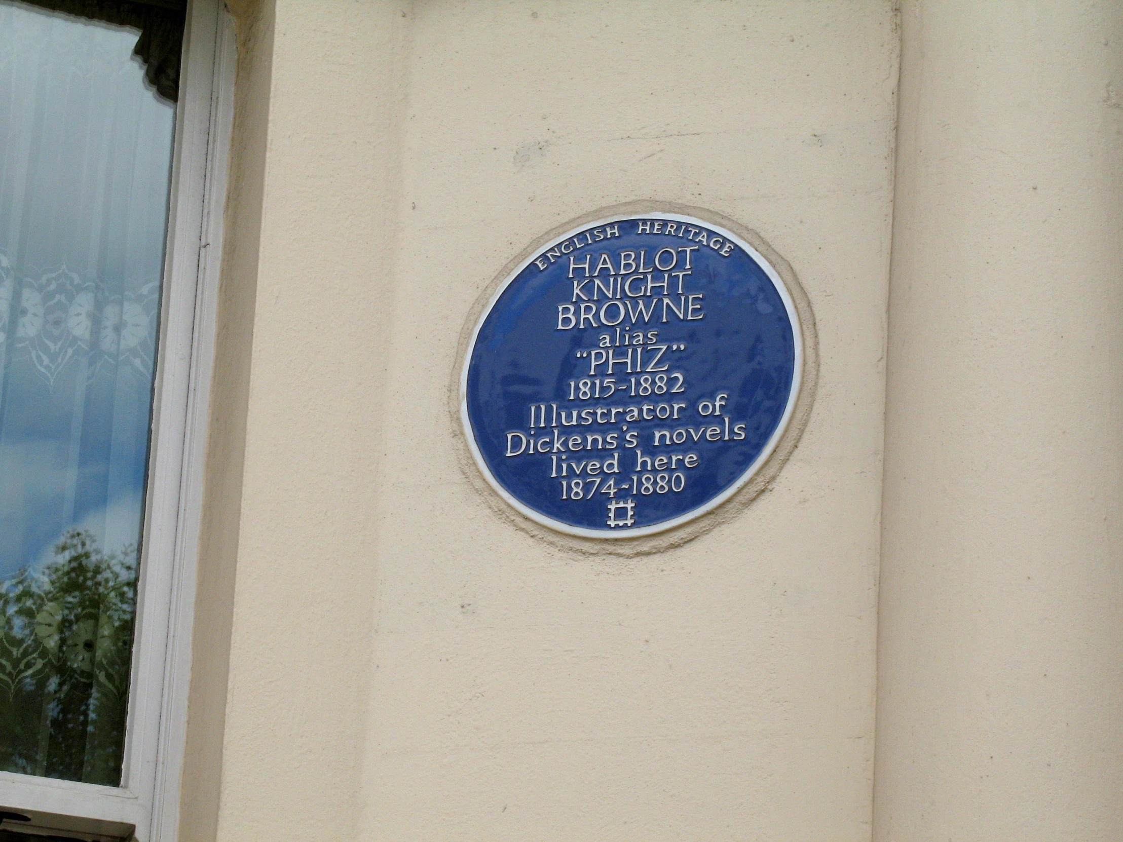 a blue plaque mounted to the side of a building