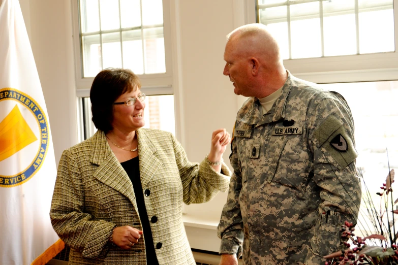 woman in military uniform holding hands with man at a meeting