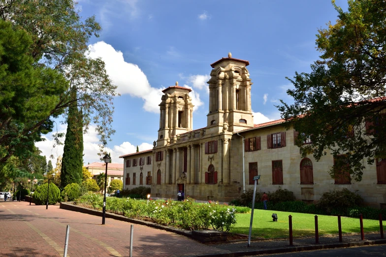 an old building with tall spires with trees in front