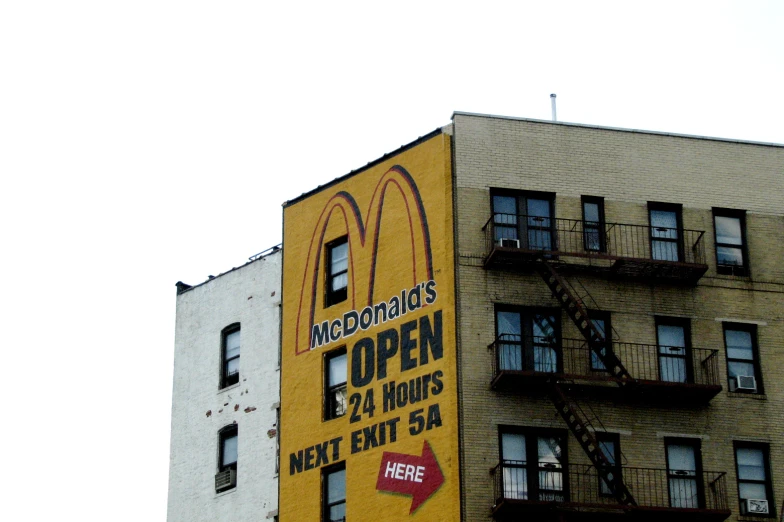 a large yellow building that has a large mcdonald's open sign on it