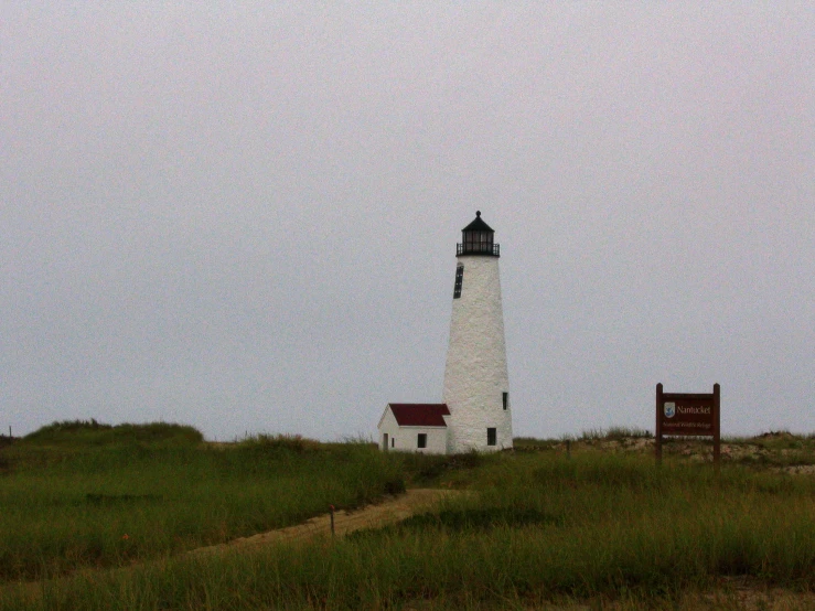 a tall lighthouse sitting on the side of a hill