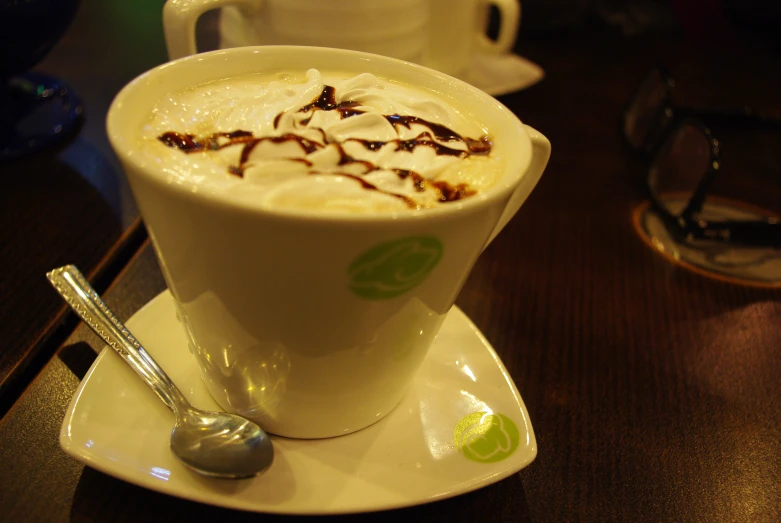 a drink in a large white cup sits on a saucer