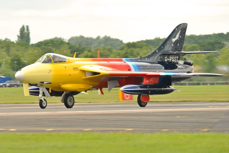 a plane with a colorful tail on an airport runway