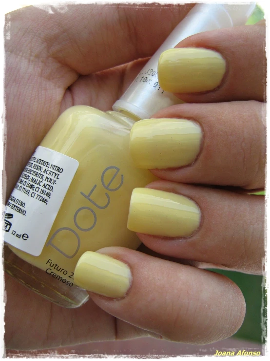 a woman is holding a yellow manicure