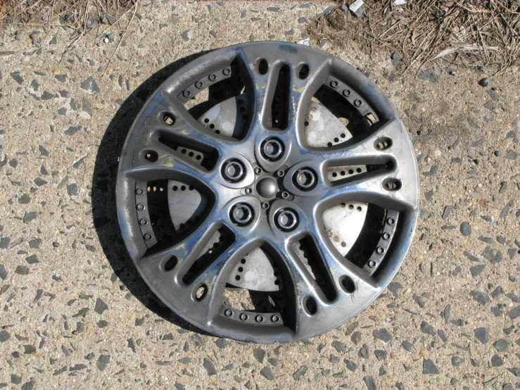 a round metal object sitting on top of a sidewalk