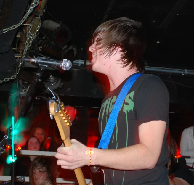 a person playing guitar in front of a microphone