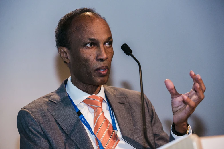 a man in suit and tie giving a speech