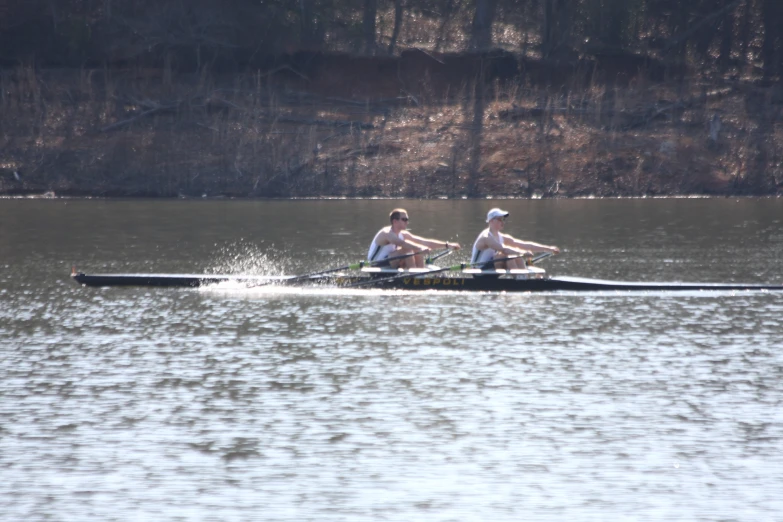 two people in a long boat on a body of water