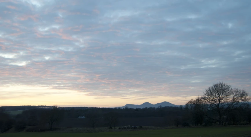 the sky has been changed to pink as the sun sets over mountains