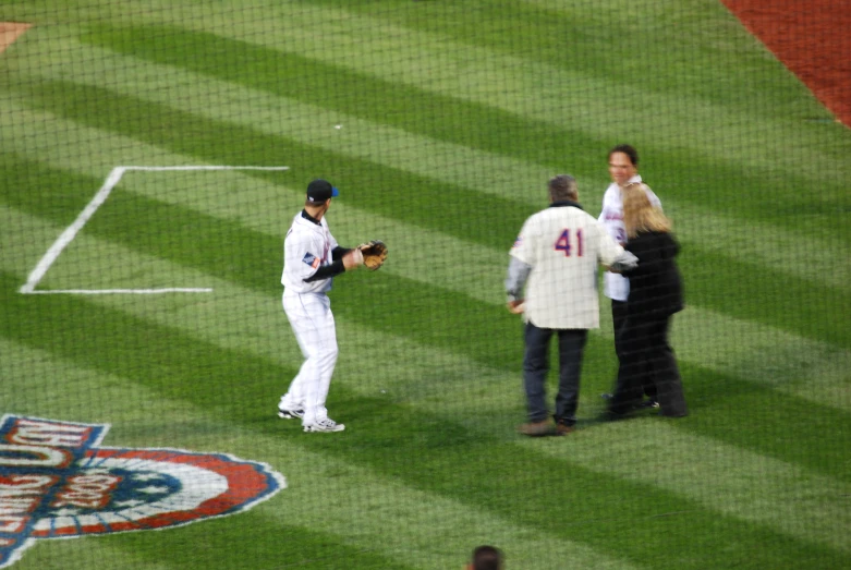 a couple of men standing on top of a baseball field