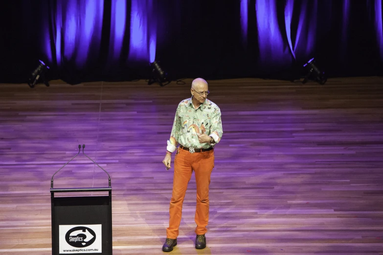 a man standing on a stage in front of a podium