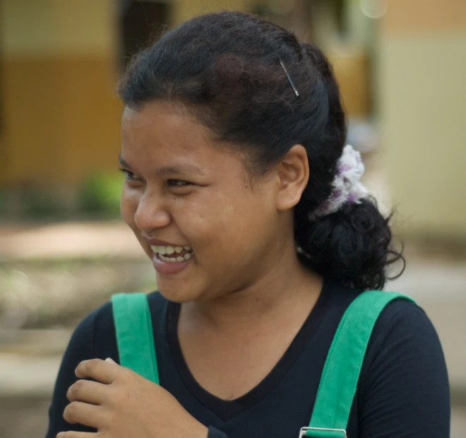 a woman is smiling while holding a cellphone