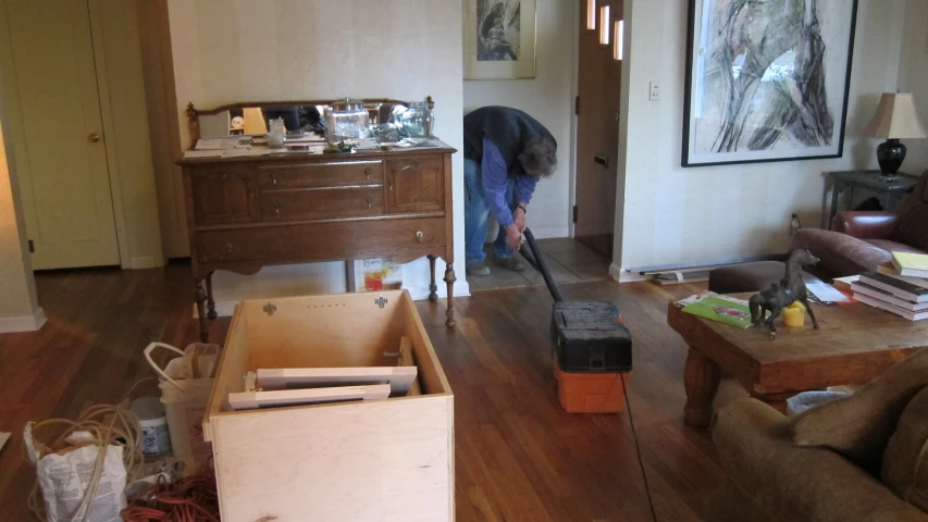 a man vacuums through the middle of his living room