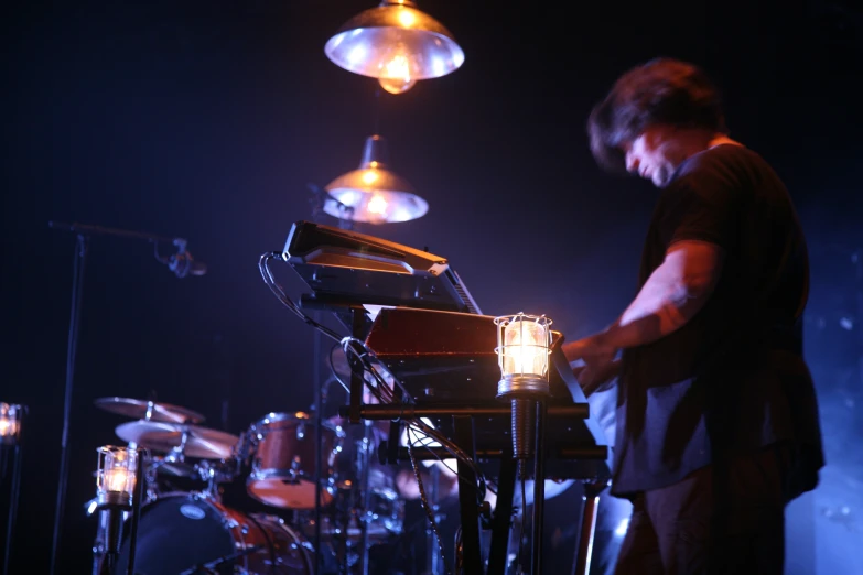 the man is playing piano in front of the lights