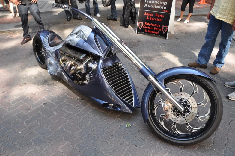 a custom motorcycle parked next to people on the street