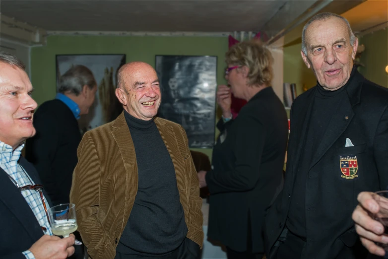 two older men smile and stand beside another man in a bar