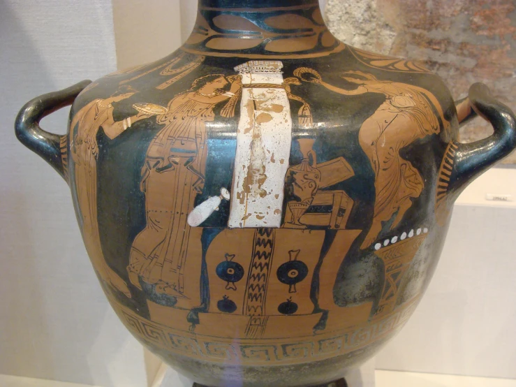 an antique vase with some people on it