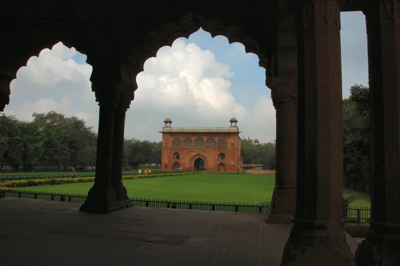 an old building is located in a large grassy field