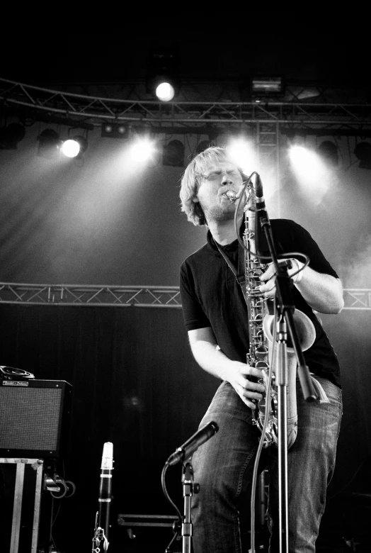 a man in a black shirt is playing the guitar on stage