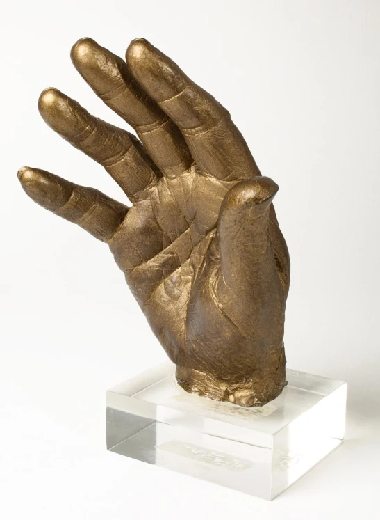 a statue of a hand with a golden hand on it