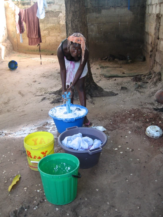 a woman is putting soing in colorful buckets