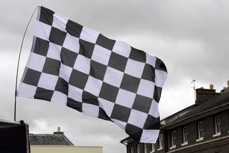 black and white checkered flag on pole in front of buildings