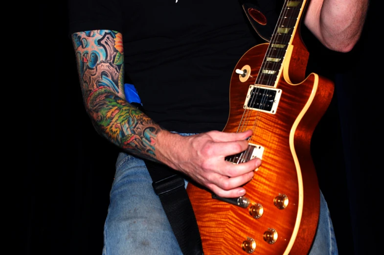 a close up of a man holding an electric guitar