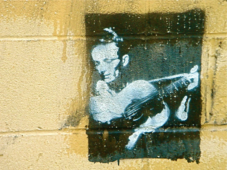 a man playing the guitar painted on a wall