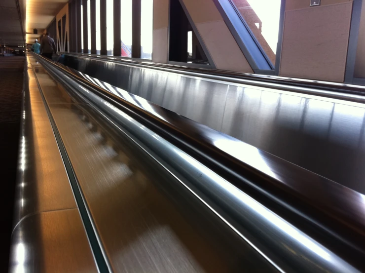 a shiny long metal conveyor belt in a building