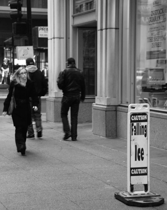 two people standing next to each other by a street sign