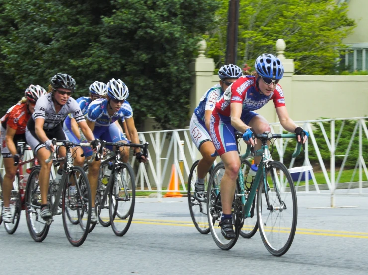 group of bikers on roadway with cars nearby during daytime