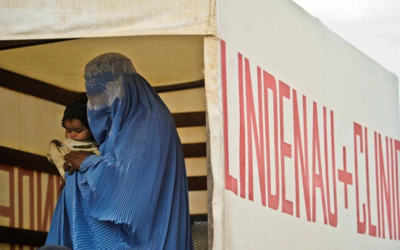 a woman standing outside of a white truck