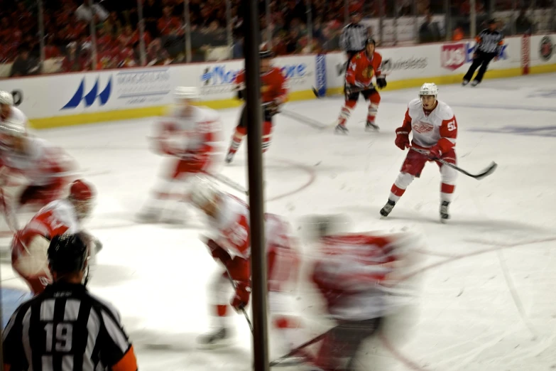 a professional ice hockey game with the players and referee looking at the opposing team