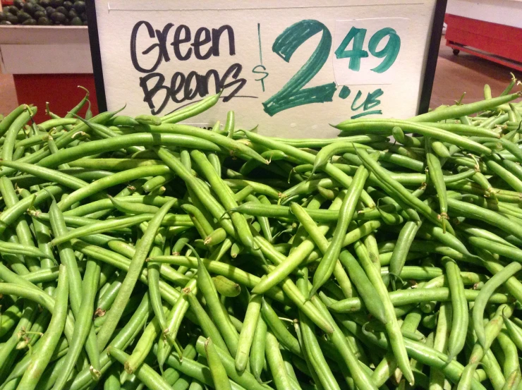 several varieties of green beans displayed in a market