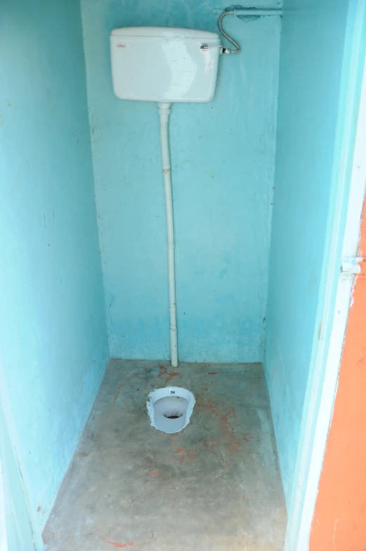 small bathroom with white toilet next to a blue wall