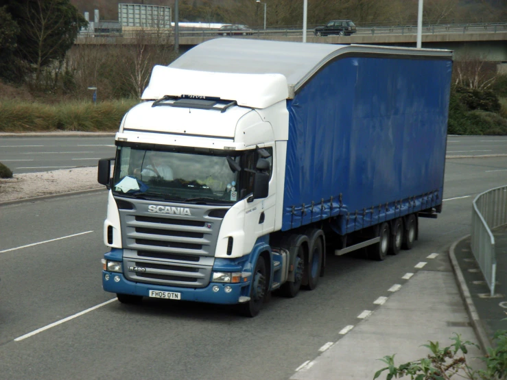 a blue and white truck on a city road