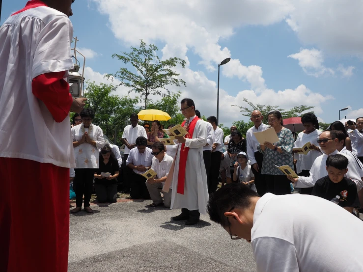 a priest is kneeling with other people