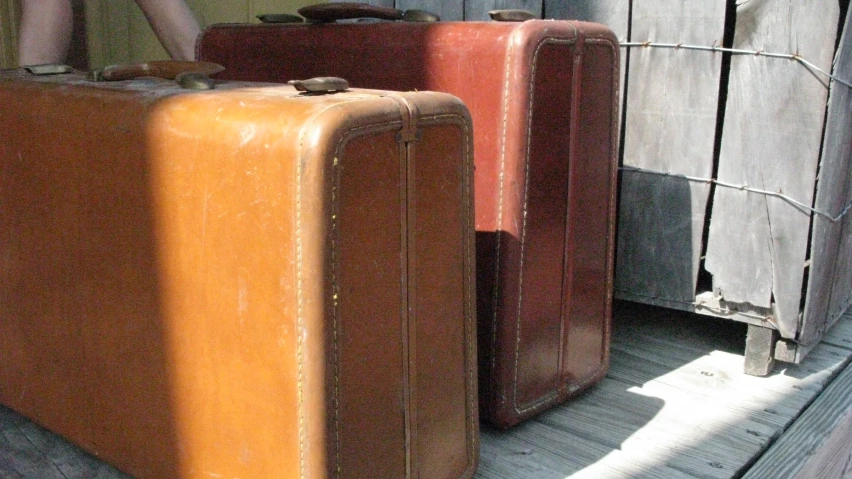 some brown suitcases sitting outside of a door