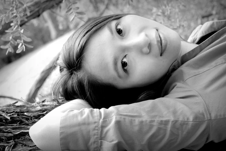 a beautiful young woman laying on the ground