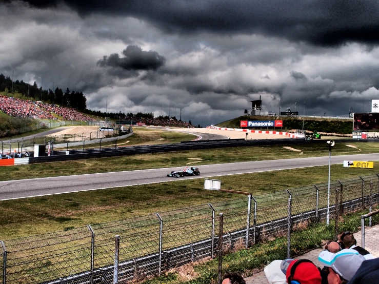 cars driving down the track on a cloudy day