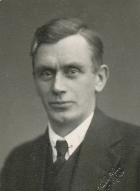 an old black and white po shows a man wearing a suit and tie