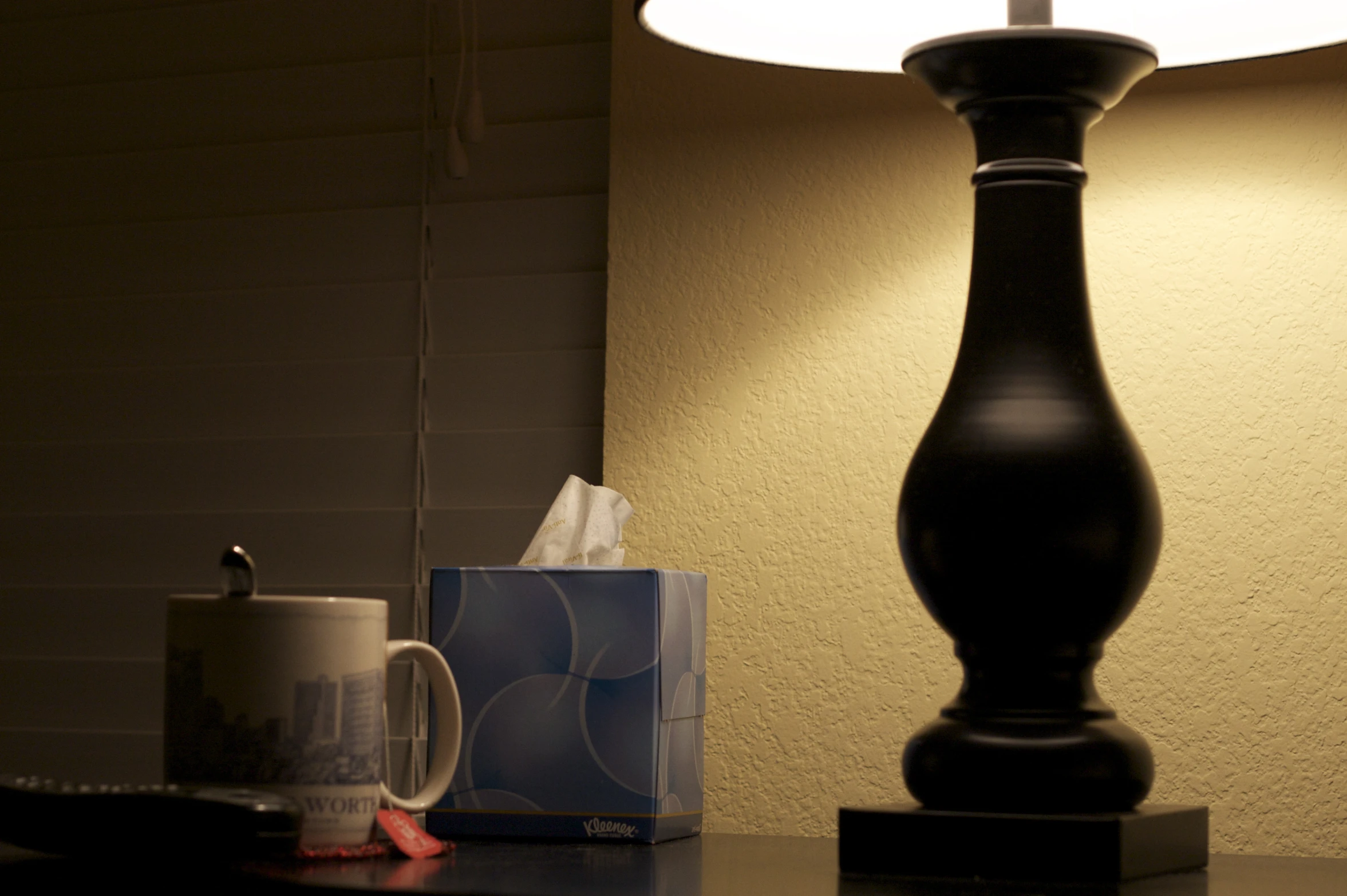 a black lamp sitting on a table next to a mug