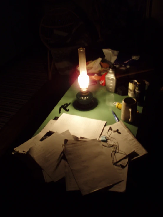 a lighted candle on top of some papers