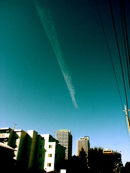 an airplane in a blue sky over a city street