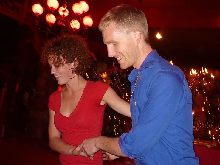 a man and a woman dancing on the dance floor